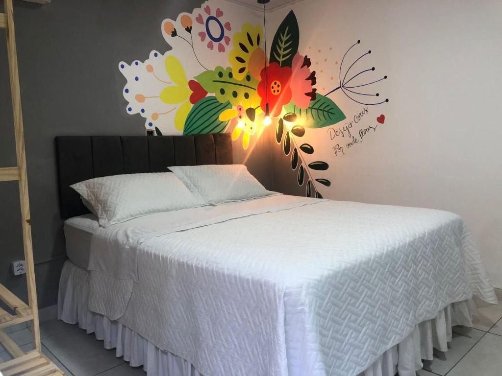 a bedroom with a bed with a flower mural on the wall at Top Coliving I in Cuiabá