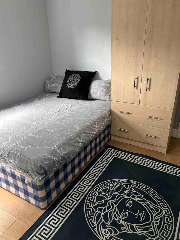 a bedroom with a bed and a cabinet and a rug at Studio apartment in London