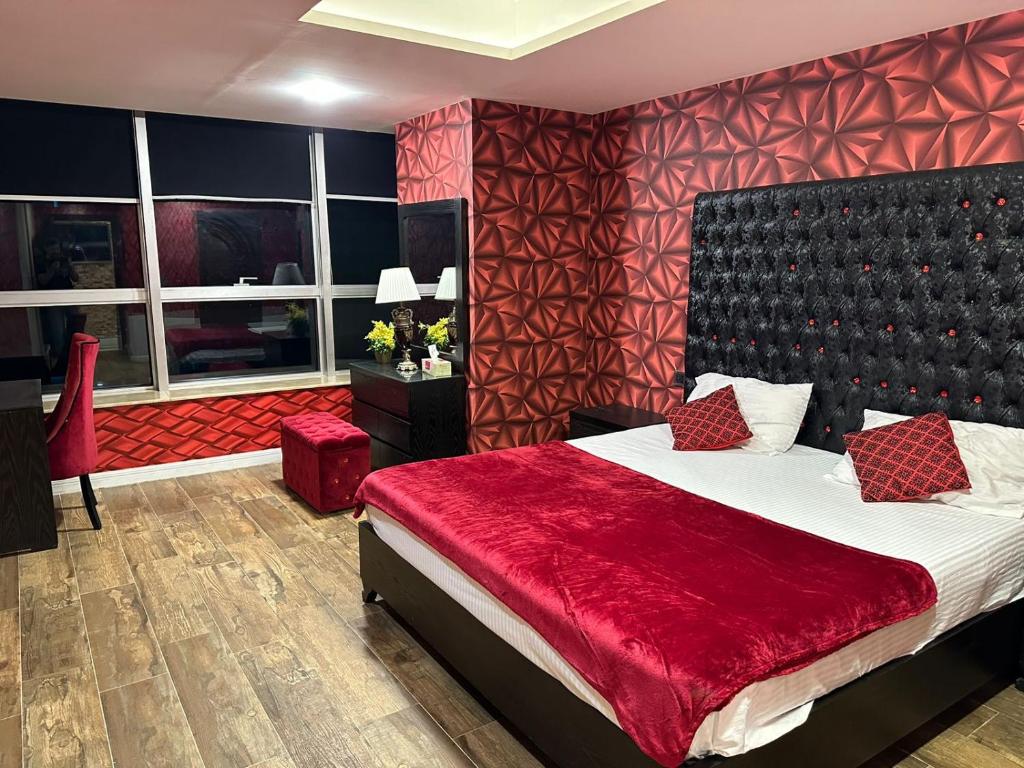 - une chambre avec un grand lit et une couverture rouge dans l'établissement Centaurus Apartment Islamabad, à Islamabad