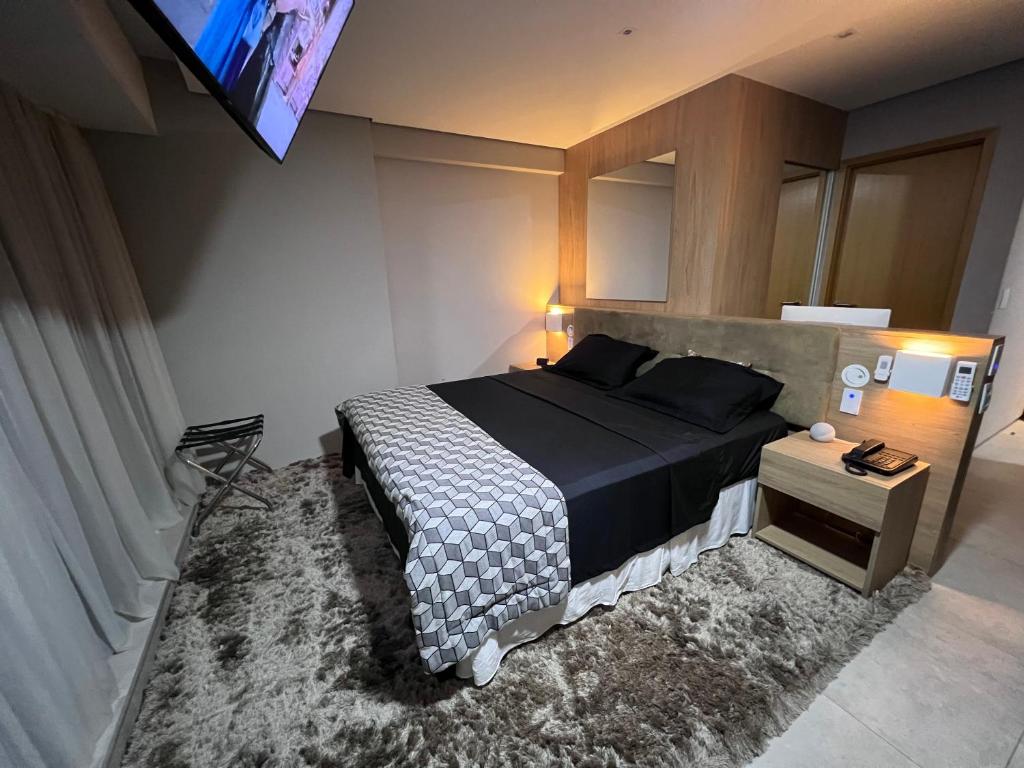 a bedroom with a bed and a tv on the wall at Apartamento Luxo Recife in Recife