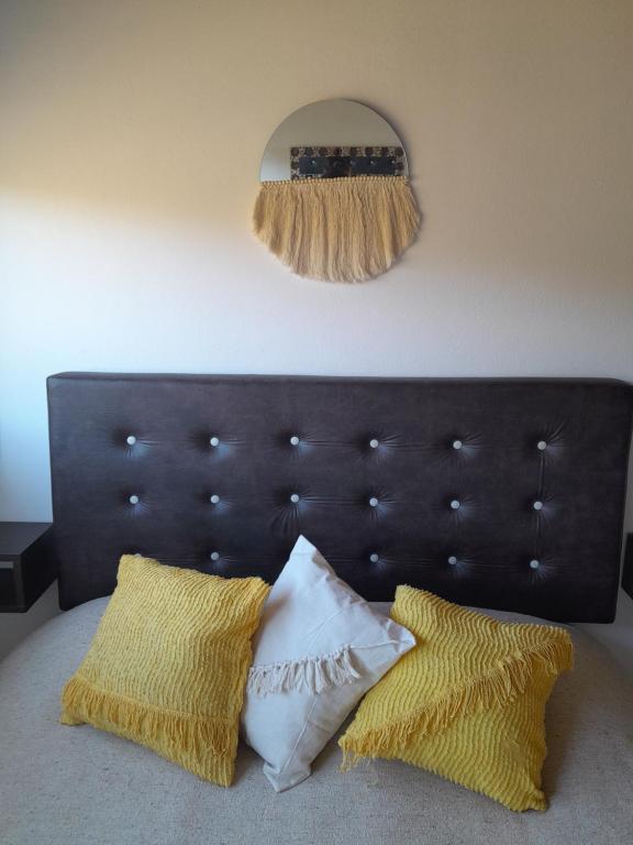 a bed with two pillows and a mirror on the wall at La Allandesa in Cavalango