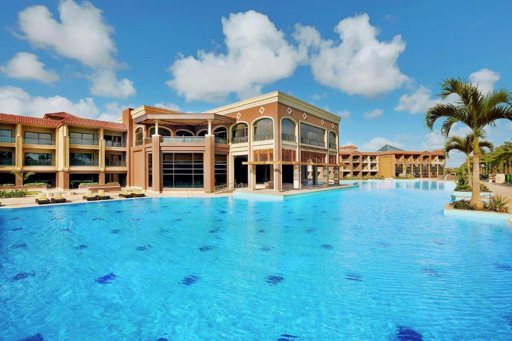 a large swimming pool in front of a resort at Hilton Alexandria King's Ranch Hotel in Alexandria