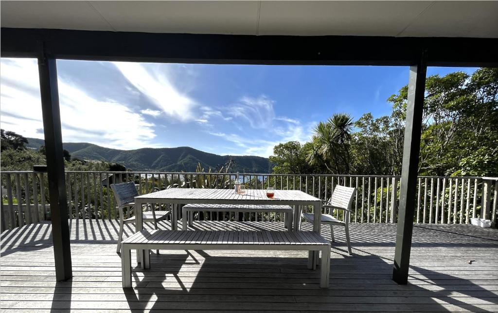 una mesa y 2 sillas en una terraza con vistas en Waikawa Bay bach with spectacular views, en Waikawa