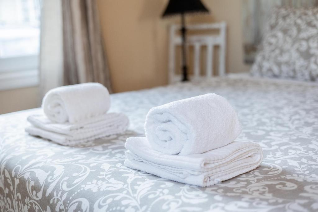 two stacks of towels sitting on top of a bed at KABACEIRA VILLAGE in Atalaia