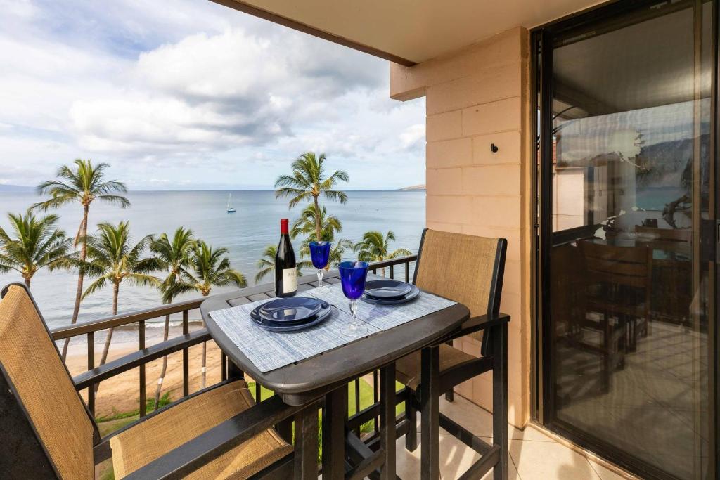 a table on a balcony with a view of the ocean at Kealia Resort 601 in Kihei