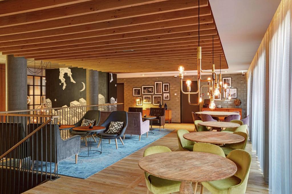 a hotel lobby with tables and chairs and a lobby at Canopy by Hilton Reykjavik City Centre in Reykjavík