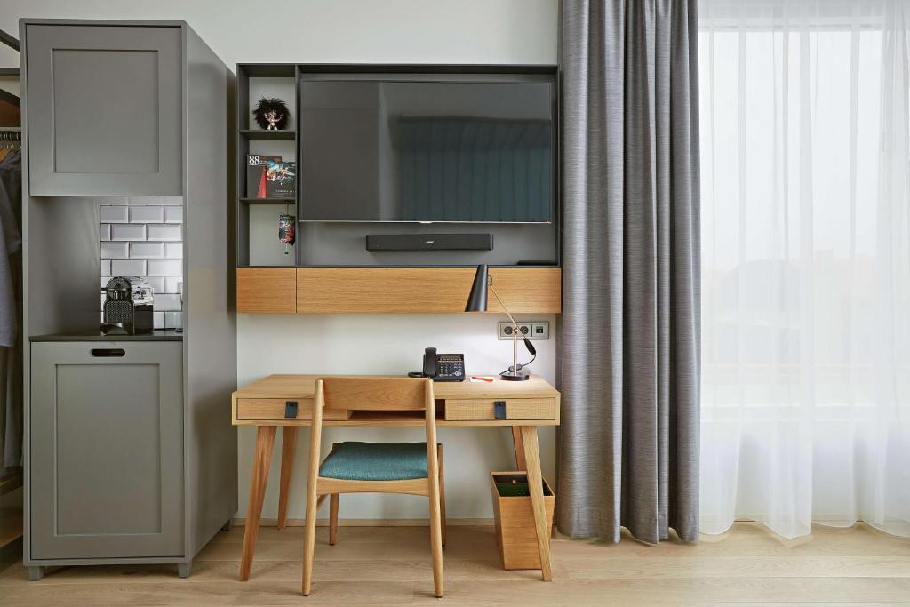 a desk with a chair and a television in a room at Canopy by Hilton Reykjavik City Centre in Reykjavík