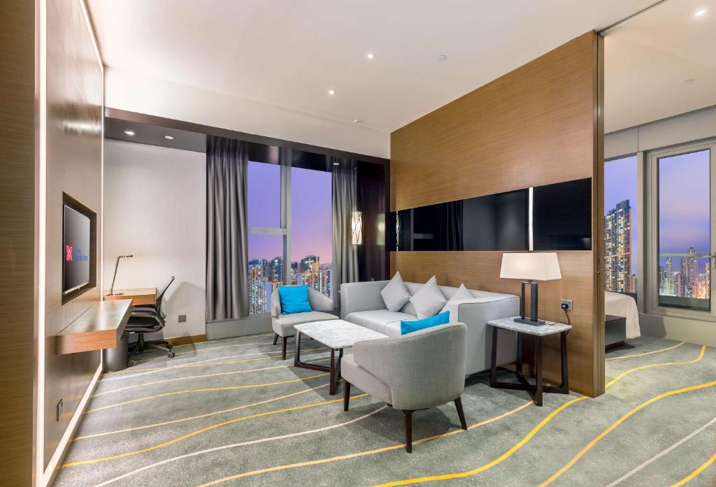 una camera d'albergo con divano e scrivania di Hilton Garden Inn Hong Kong Mongkok a Hong Kong