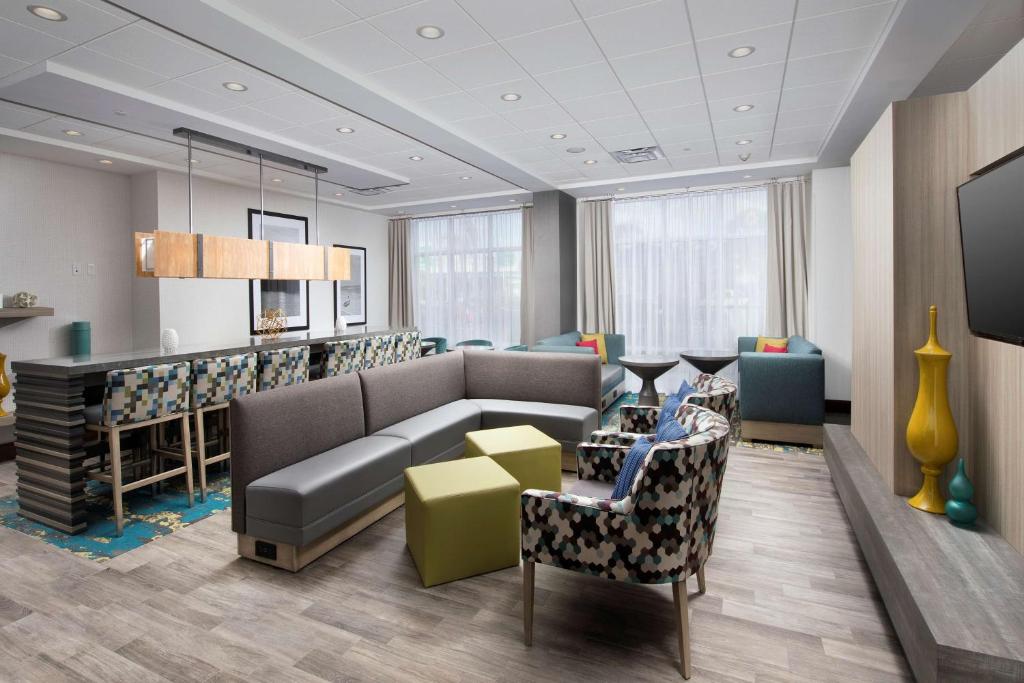 eine Lobby mit Sofa und Stühlen und einer Bar in der Unterkunft Hampton Inn Miami Airport East in Miami