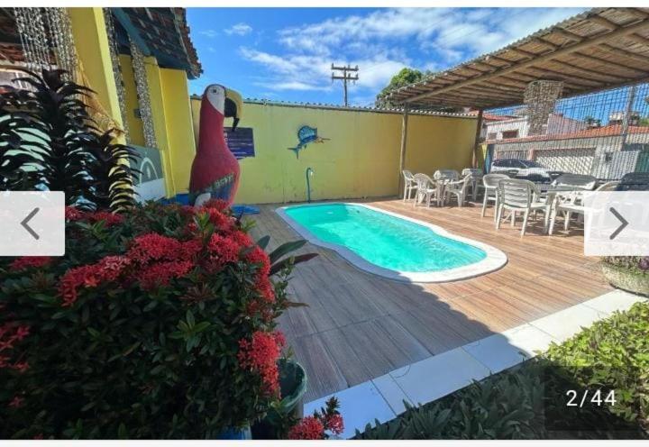 ポルト・デ・ガリーニャスにあるPOUSADA CÉU AZULのスイミングプール、テーブルと椅子が備わる家