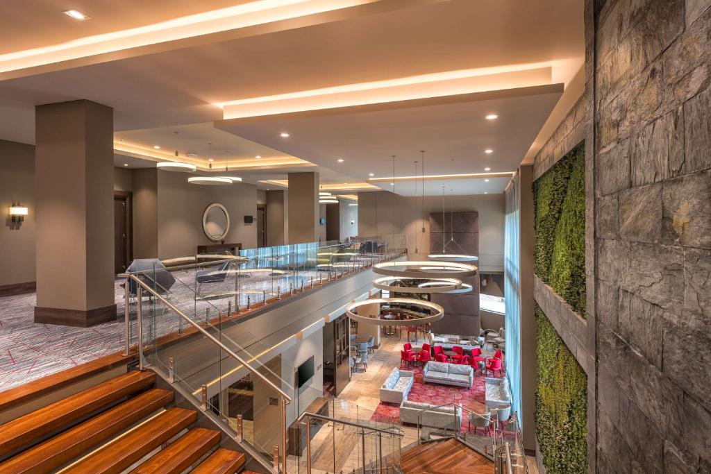 a lobby of a hotel with a staircase and a bar at Hilton Garden Inn Bogota Airport in Bogotá