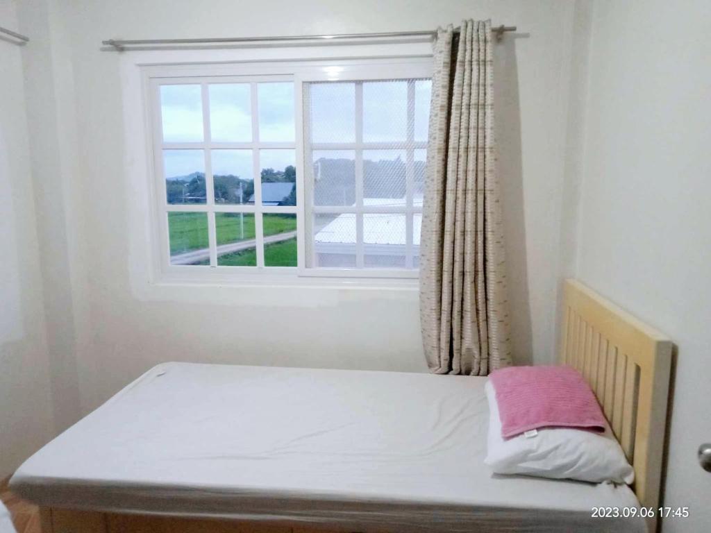 ein kleines Bett in einem Zimmer mit Fenster in der Unterkunft Budget room with split type air-condition in San Fernando