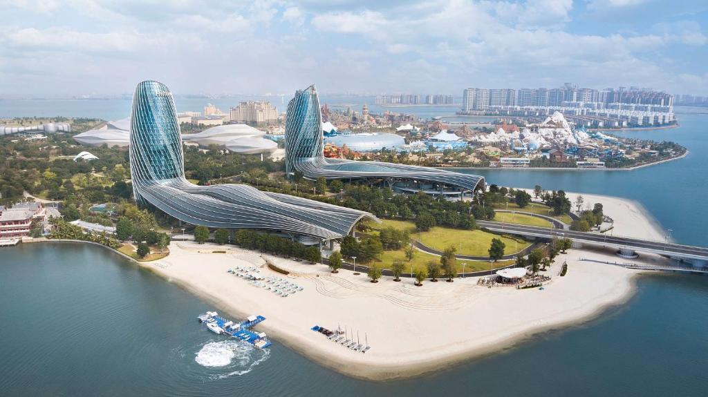 two futuristic buildings on an island in the water at Hilton Hainan Ocean Flower Island in Danzhou