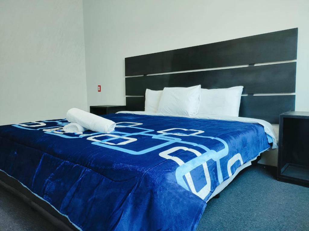 een bed met een blauwe deken erop bij Hotel Boutique Otomi cerca de Tolantongo in Cardonal