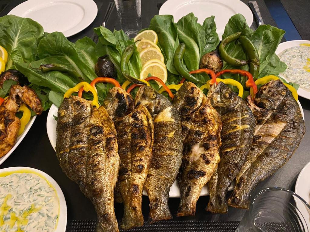 a bunch of fish on a plate with rice and vegetables at laperla chalet villa di lusso deadsea in Sowayma