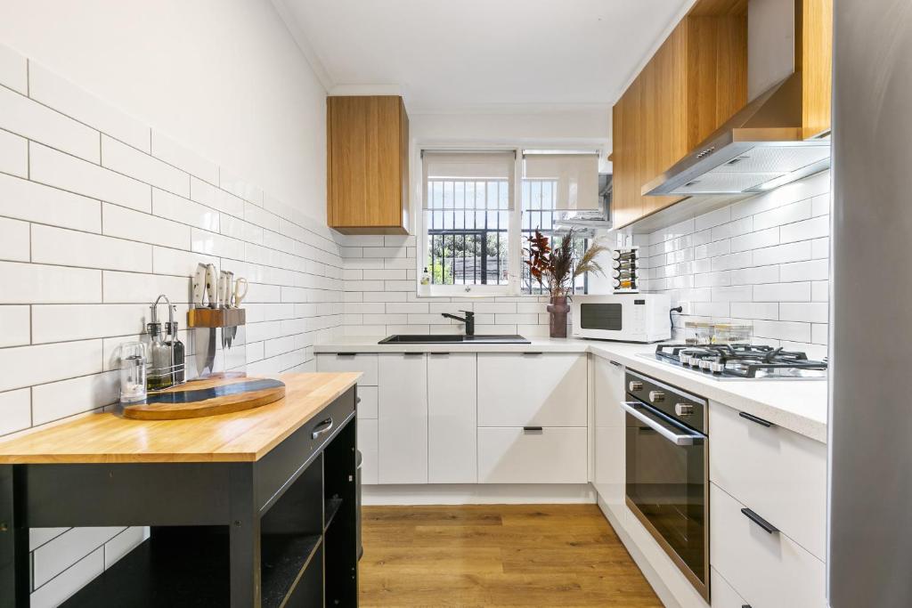 a kitchen with white appliances and a wooden counter top at The Newstead in Melbourne