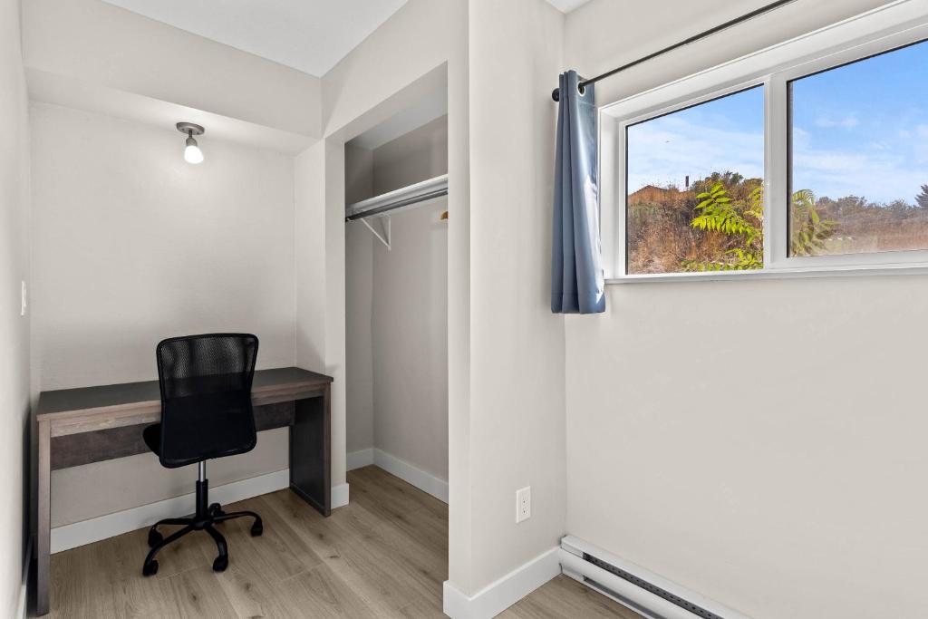 a desk and a chair in a room with a window at The Vista Inn in Kamloops