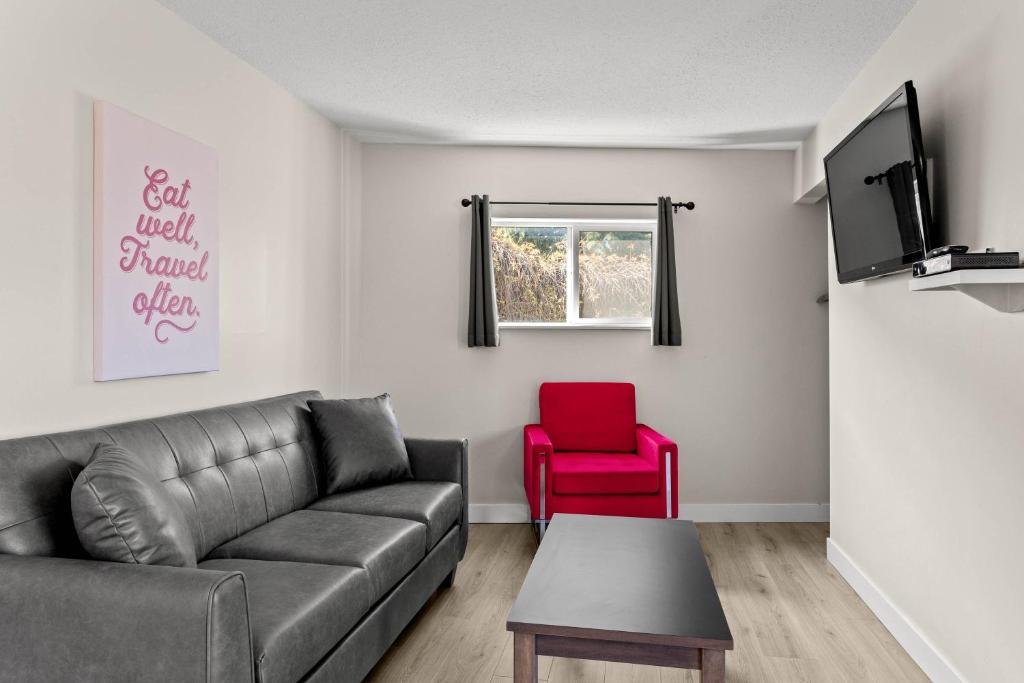a living room with a couch and a red chair at The Vista Inn in Kamloops