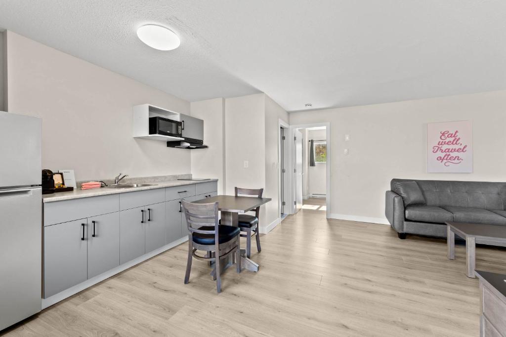 a kitchen and living room with a table and a couch at The Vista Inn in Kamloops