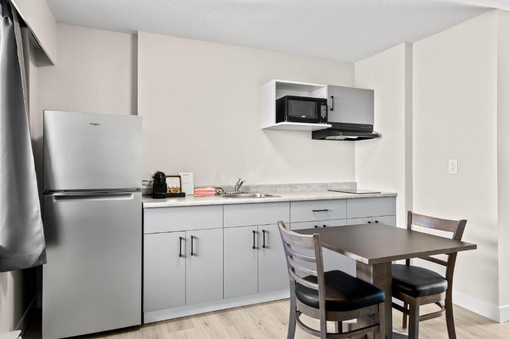a kitchen with a table and a refrigerator at The Vista Inn in Kamloops