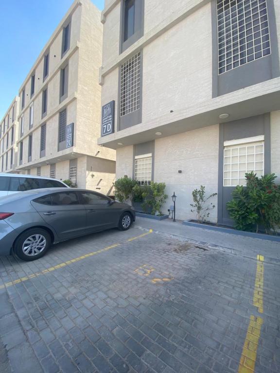 a car parked in a parking lot in front of a building at Luxury Apartment in Riyadh