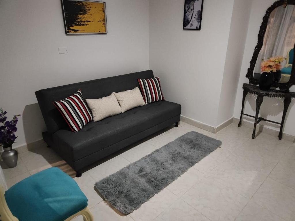 - un salon avec un canapé noir et un tapis dans l'établissement Cómodo estudio vía termales, à Santa Rosa de Cabal