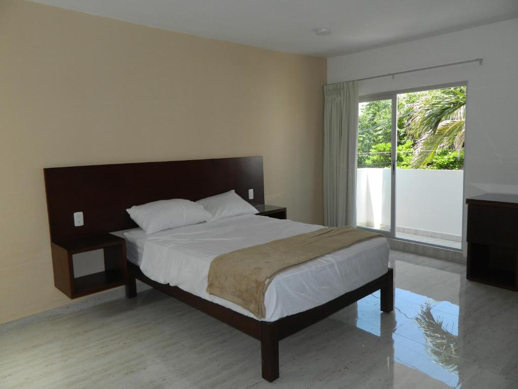 a bedroom with a bed and a large window at ACL Suites in Boca del Río