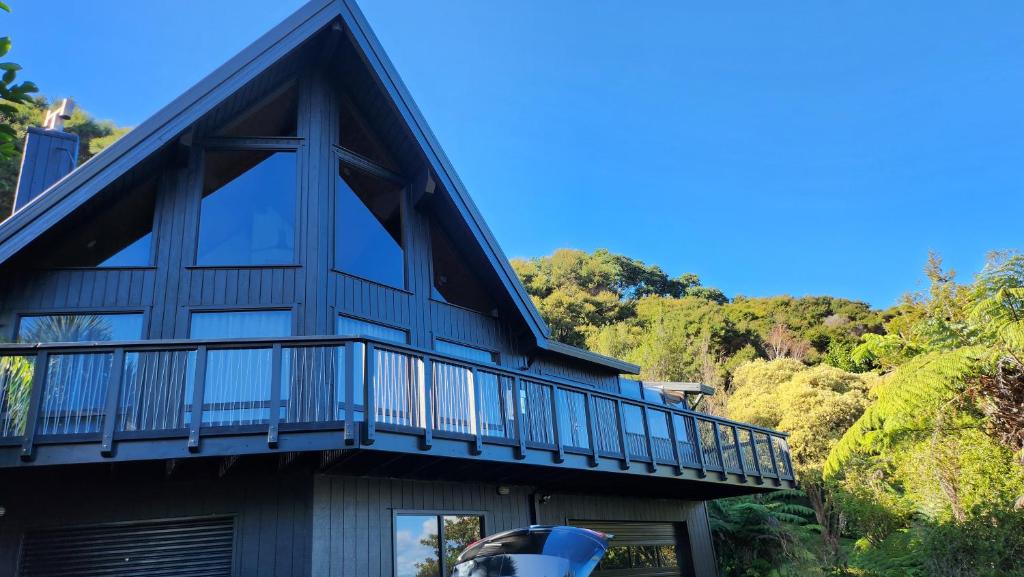 a house with a balcony on the side of it at The Black Chalet in Whitianga