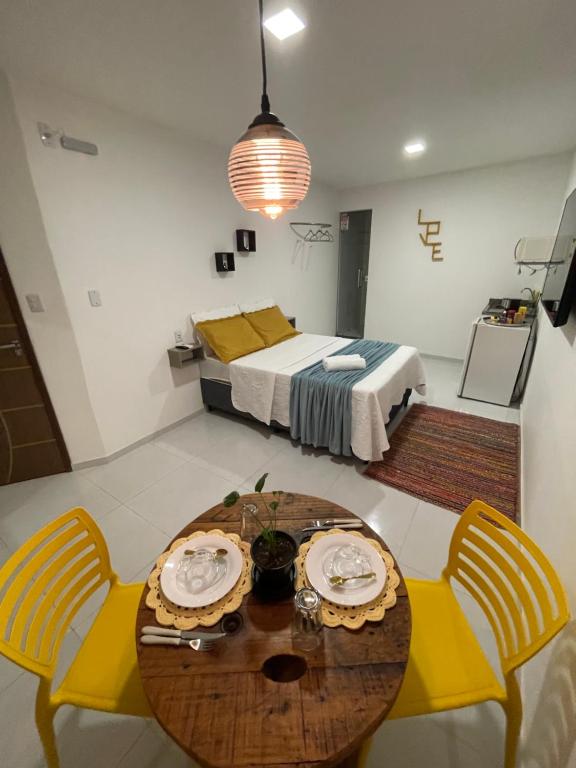 una camera con tavolo, sedie e letto di Suite Sol - Residencial Vivas a Praia do Forte