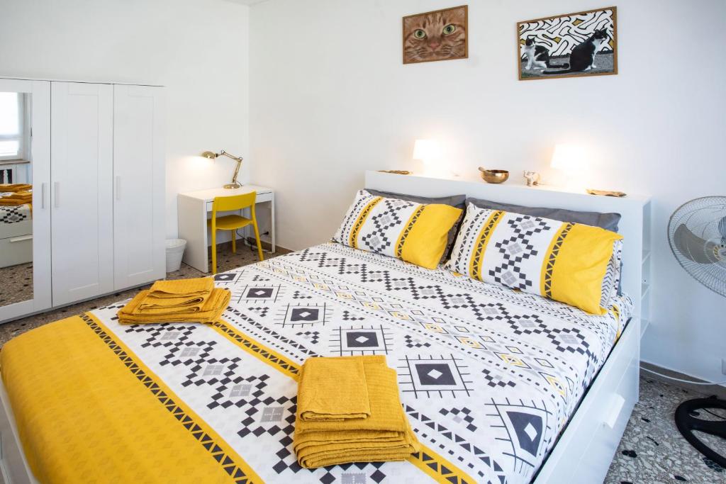 een slaapkamer met een bed met gele en witte lakens bij DarshanHome Circo Massimo in Rome
