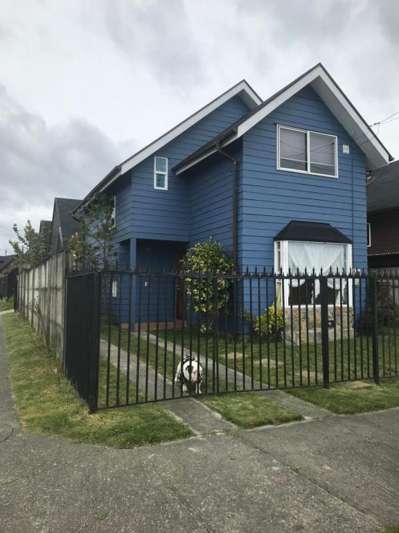 a blue house with a fence in front of it at Casa Puerto Montt in Llanquihue
