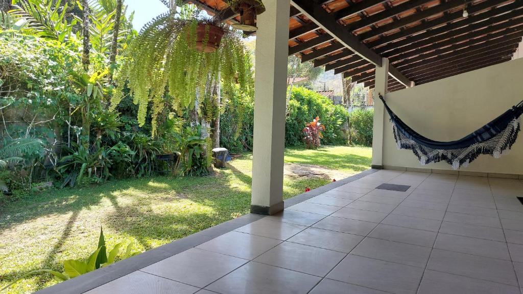 a porch with a view of a garden at Maury Chalés Boiçucanga in São Sebastião