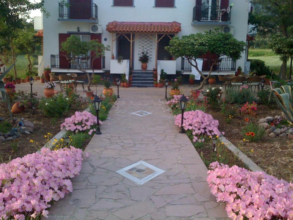 a walkway in front of a house with pink flowers at Studios Stefani in Petra