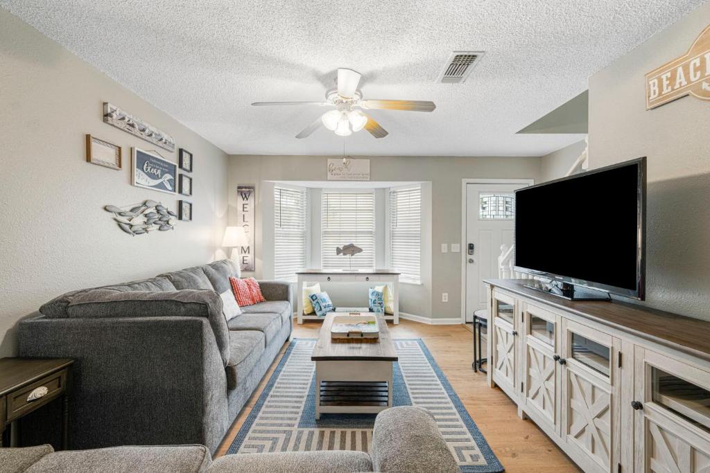 a living room with a couch and a flat screen tv at Barefoot Bungalow in Panama City Beach