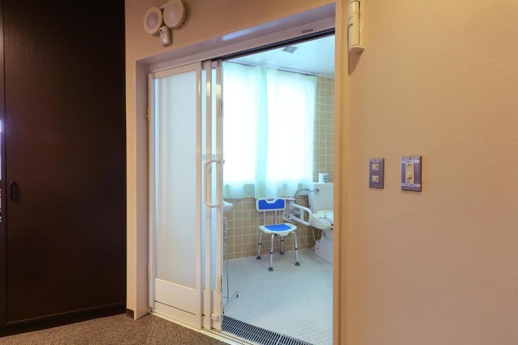 a glass door leading to a bathroom with a sink at Hotel Binario Saga Arashiyama in Kyoto