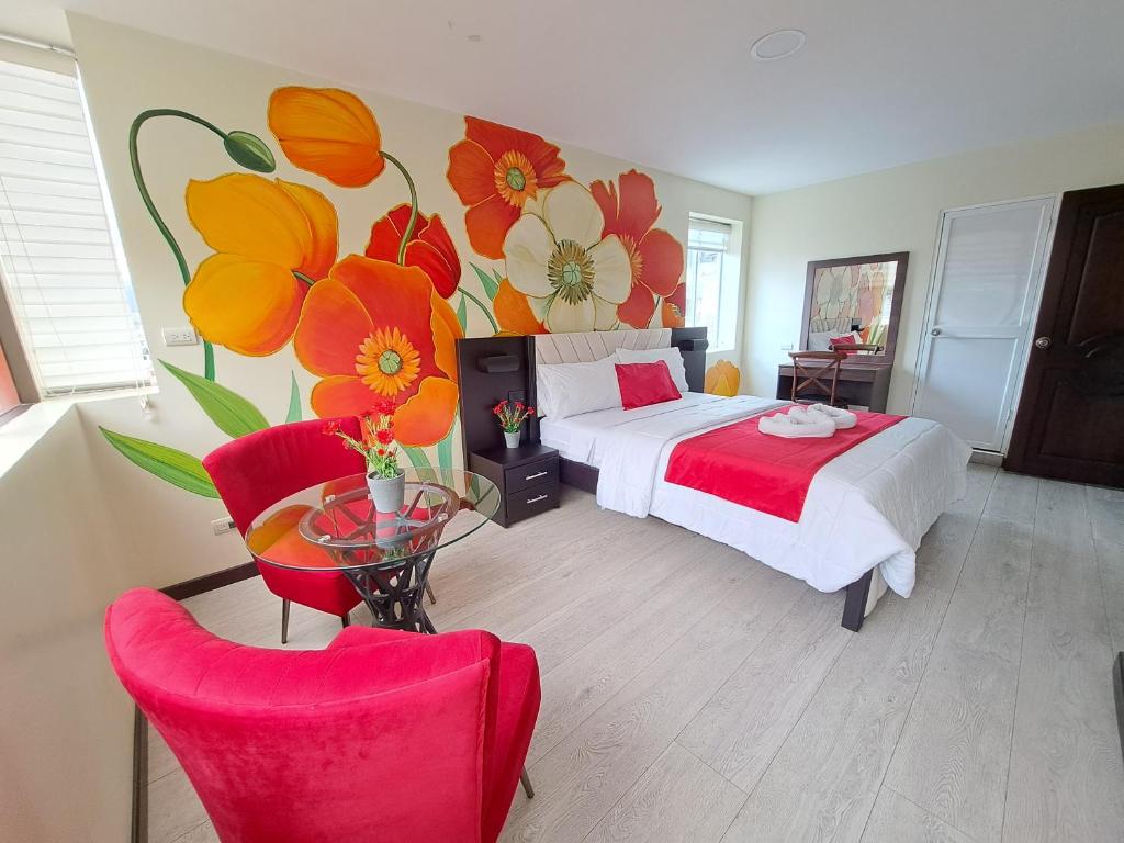 a bedroom with a bed with a flower mural on the wall at Hotel Loja Bella in Loja