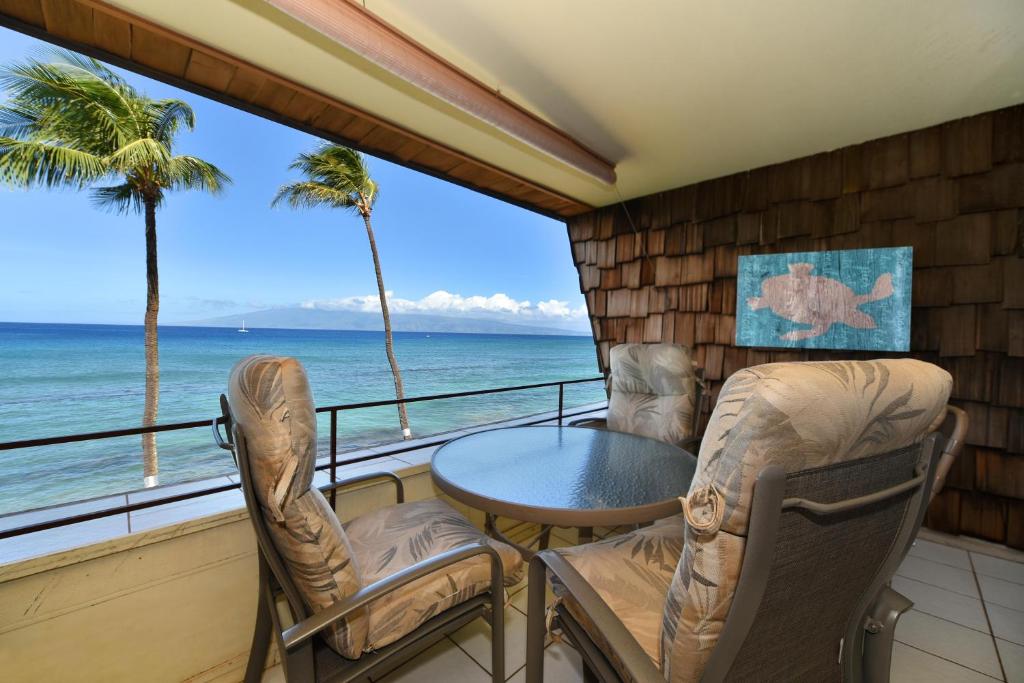 d'un balcon avec une table et des chaises et une vue sur l'océan. dans l'établissement Kulakane 304, à Kahana