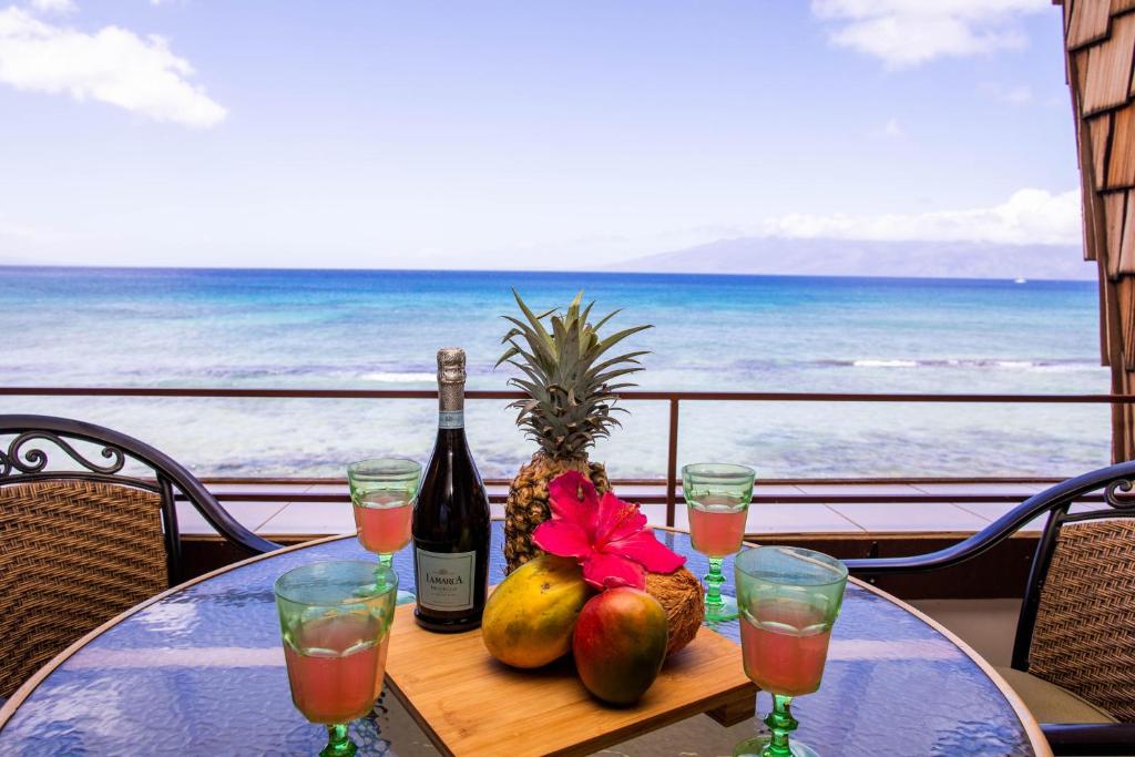 una mesa con una botella de vino y fruta. en Kulakane 306, en Kahana