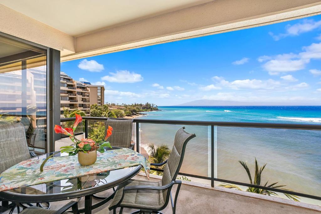 a balcony with a table and chairs and the ocean at Sands of Kahana 354 in Kahana
