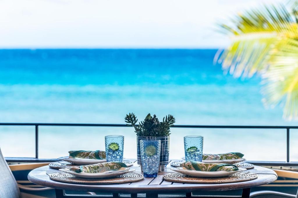 a table with plates of food and a view of the ocean at Kulakane 310 in Kahana