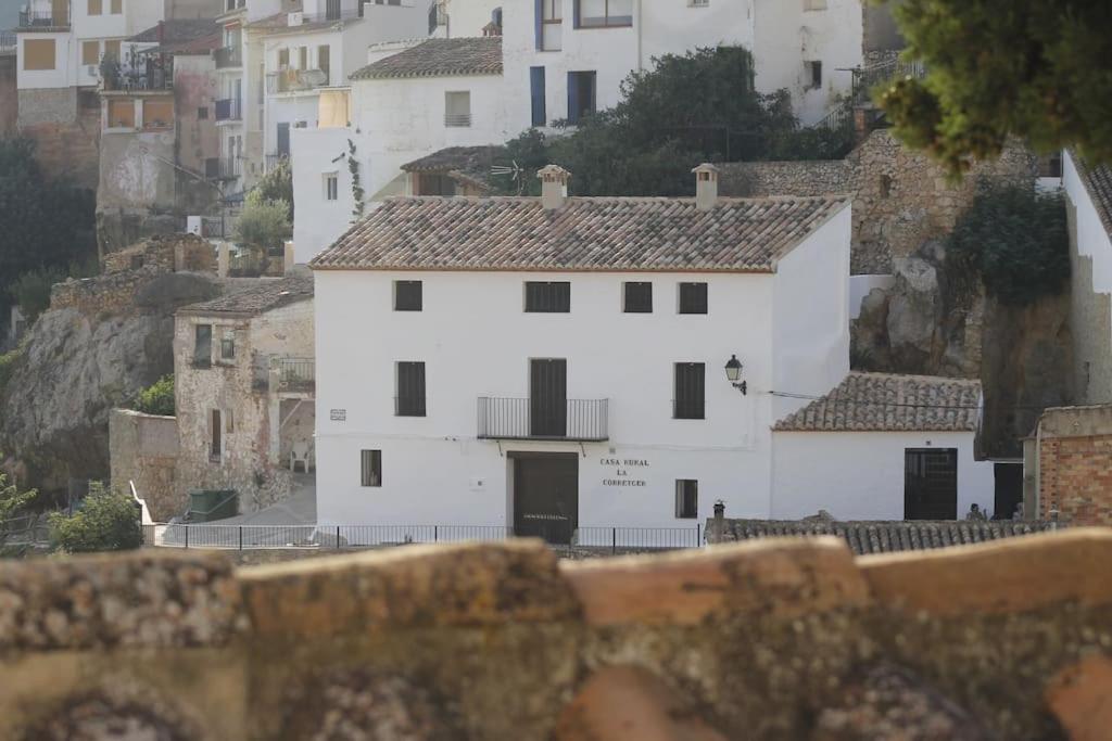 una casa blanca en una colina con edificios en Casa Rural La Corretger, en Chulilla