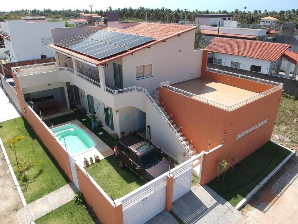 an aerial view of a house with a solar roof at Sunset Chalés in São Miguel do Gostoso