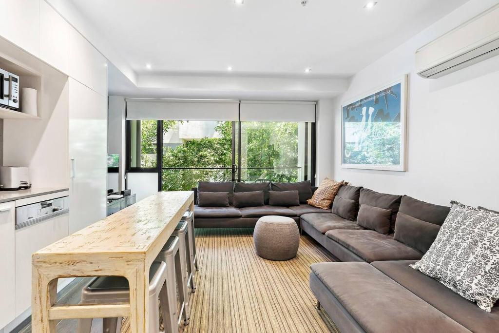 una sala de estar con un sofá y una mesa en Sunshine Place - Heart of St Kilda with Parking, en Melbourne