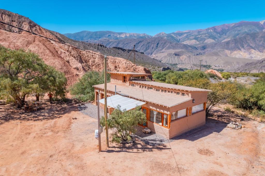 a house in the desert with mountains in the background at Cabaña Misk'i Nuna, en las afueras de Tilcara in Tilcara