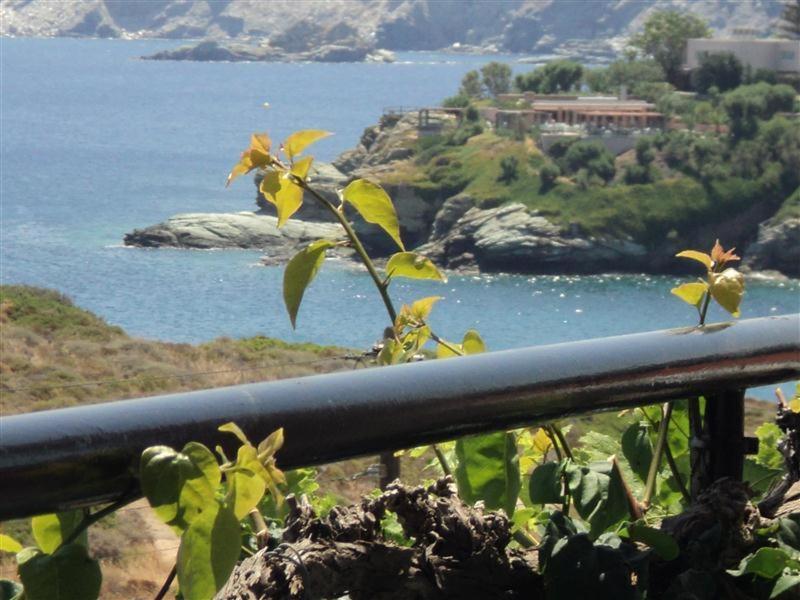 a metal railing with a view of a body of water at Evita Bay Agia Pelagia Heraklion in Agia Pelagia