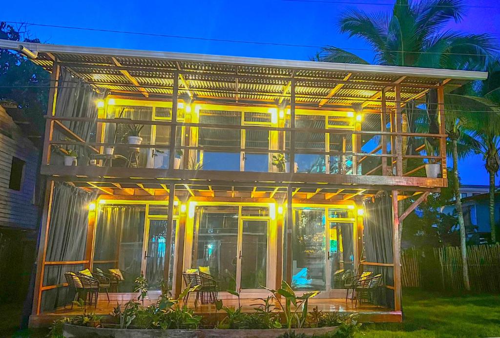 una casa con una terraza con sillas delante en Suites Bocas del Toro, en Carenero