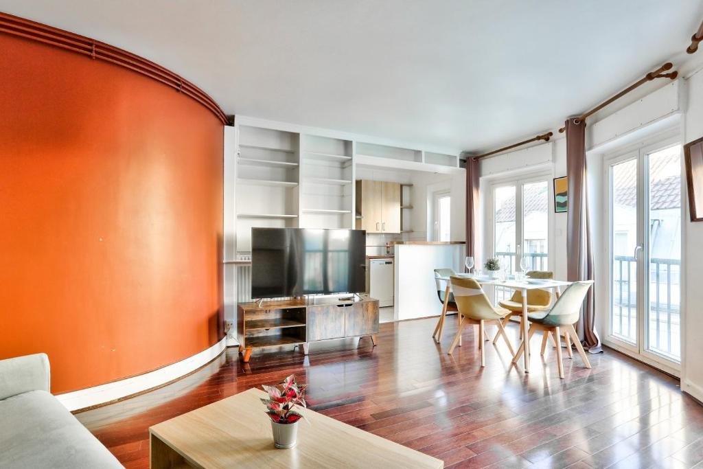 a living room with a table and a kitchen at Appartement Quartier Saint Michel in Paris