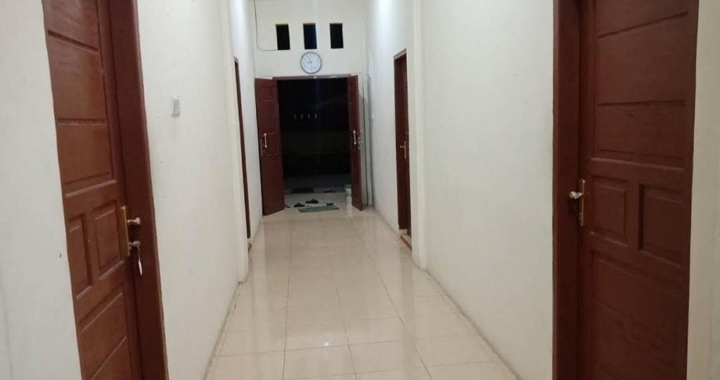Topoyo的住宿－Wisma Tiga Putra Belawa 1，墙上有时钟的空走廊和房间
