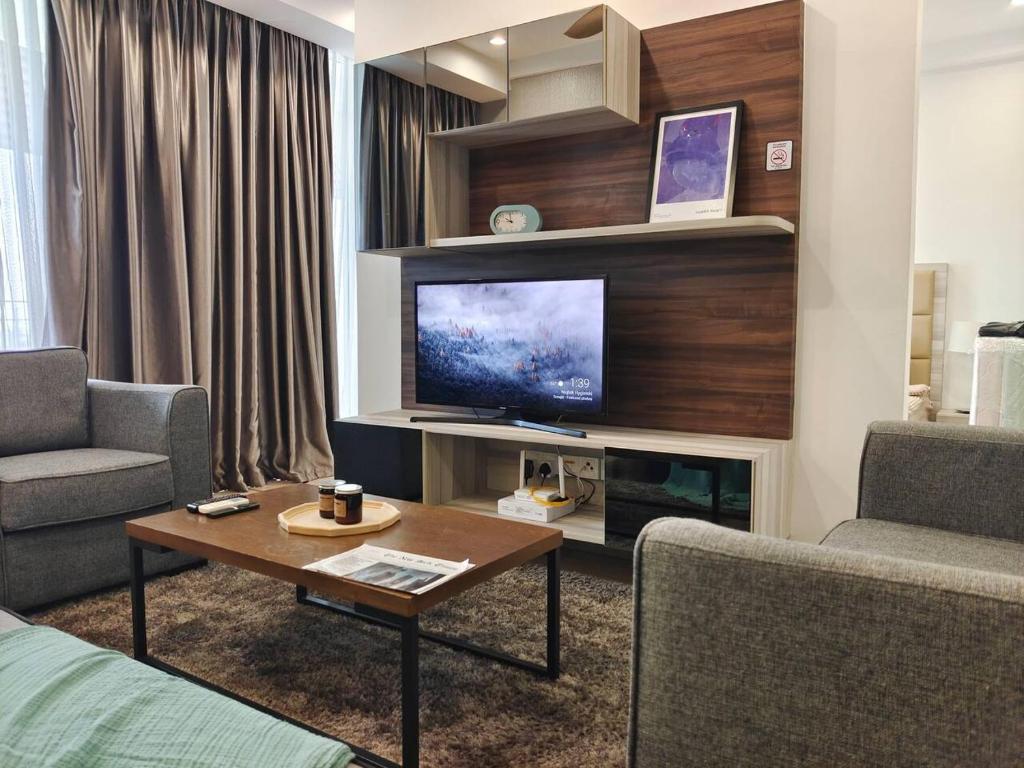een woonkamer met een tv en een bank en een tafel bij 2109 Encorp Marina Flex suite netflix By STAY in Nusajaya