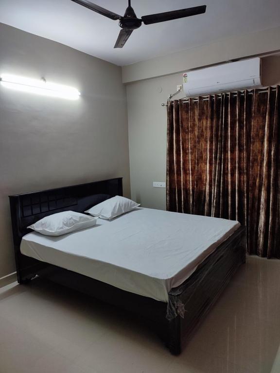 a bedroom with a bed and a ceiling fan at Rahuls castle in Visakhapatnam